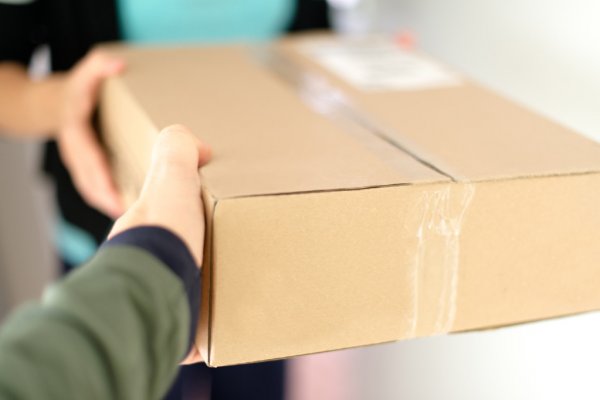 Mailman handing package to customer